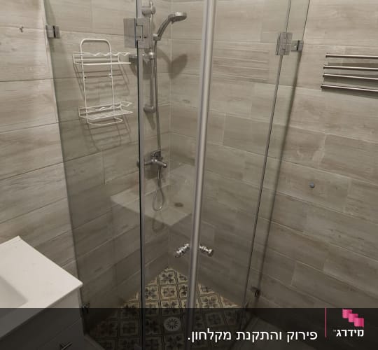 מקלחון זכוכית עם ראש מקלחת ומדף מתכת